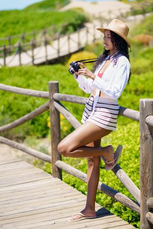 Summer Vibes A Joyful Woman in Colorful Beachwear Capturing the Beauty of Nature with her Camera