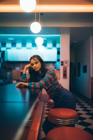 Beautiful young woman standing by bar counter