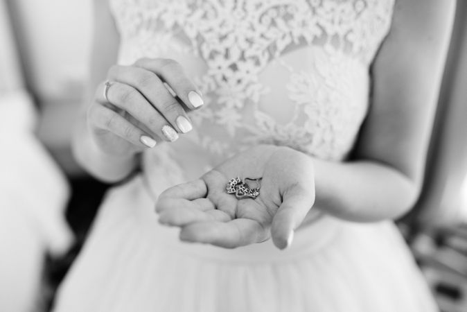 Grayscale photo of bride holding a jewelry