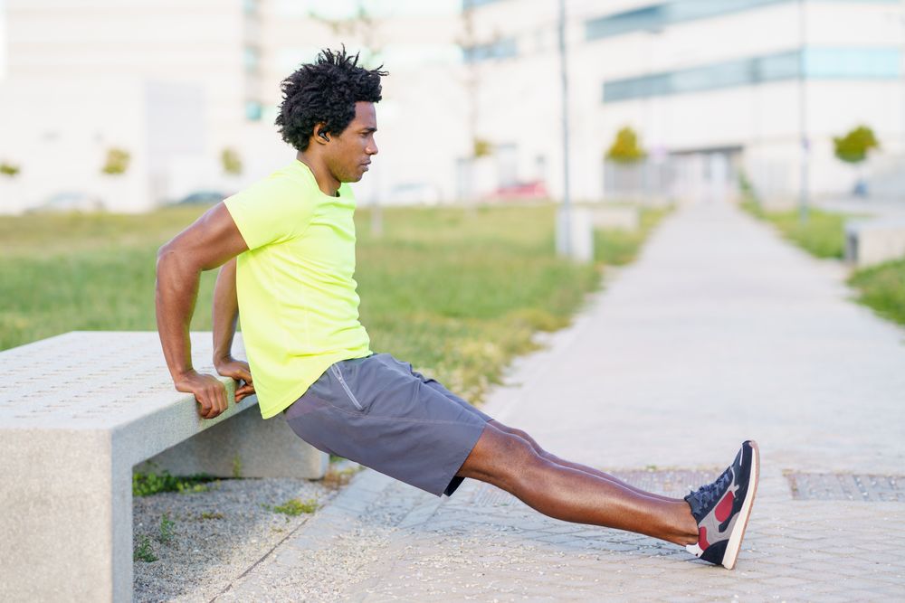 Man doing arm workouts on concrete bench