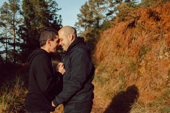 Men hugging and kissing in park