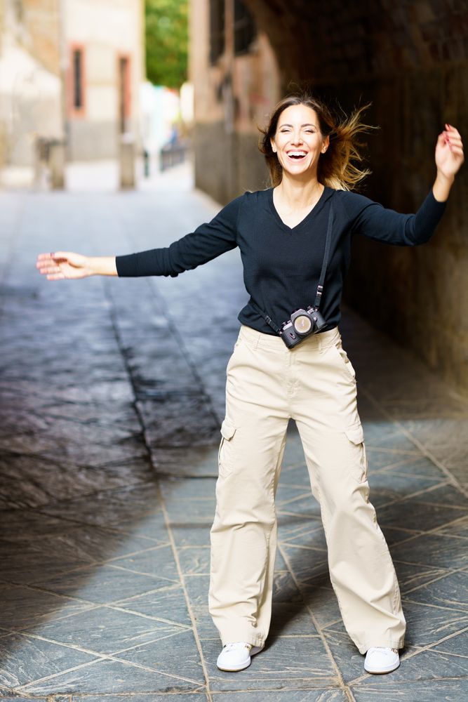 Delighted woman laughing on old street during holiday