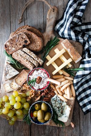 Bred, cheese, olives and grapes on wooden board