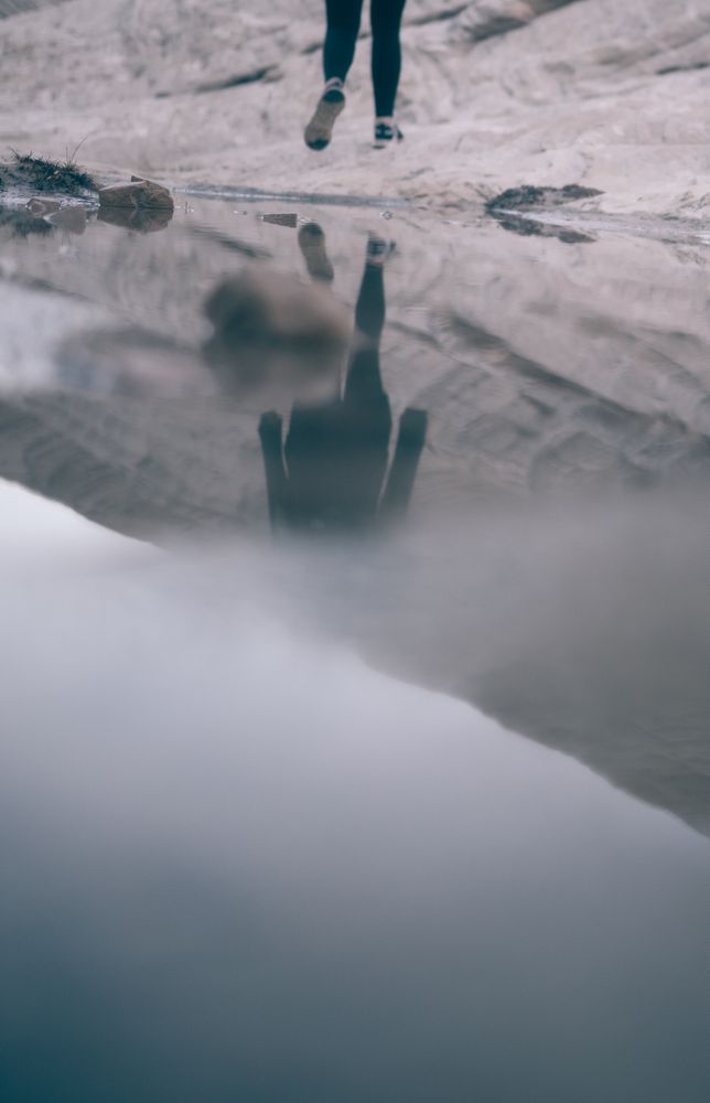 Reflection of person's legs running on body o water