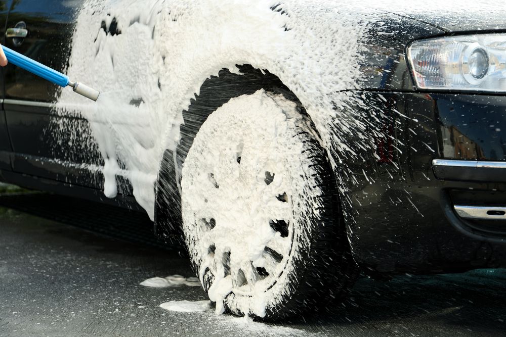 A man washes a car with foam. Clean car concept. Car wash