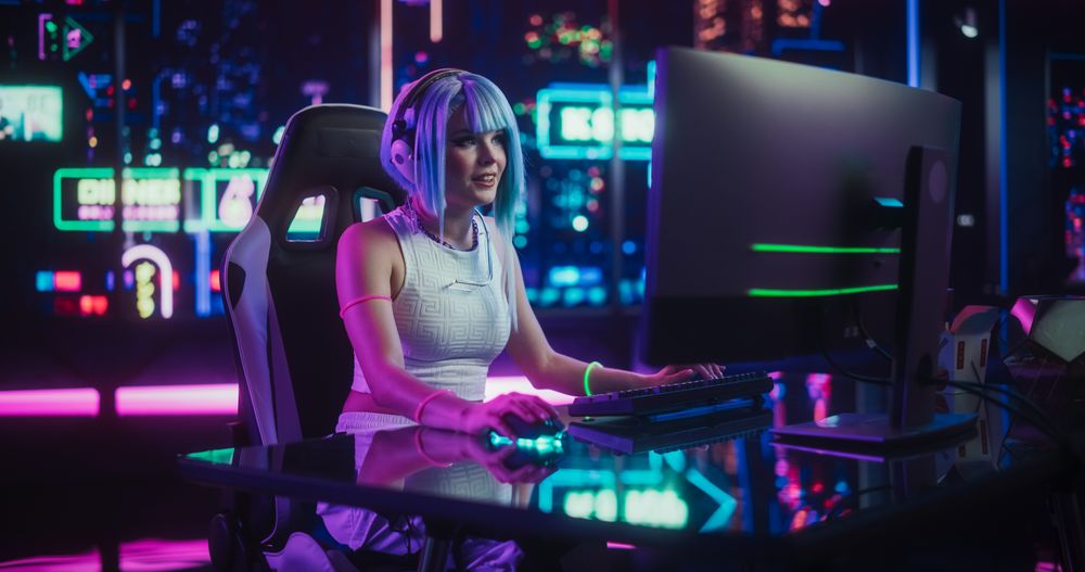 Young Woman in Futuristic Cosplay Clothes Sitting Down and Playing Video Games on a Computer.