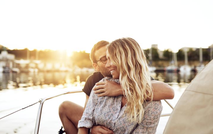 Couple embracing on a boat at sunset