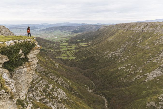 Man standing on cliff near valley