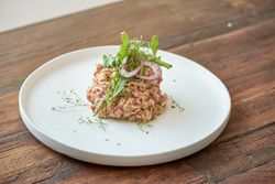 Delicious tartar with greenery on wooden table