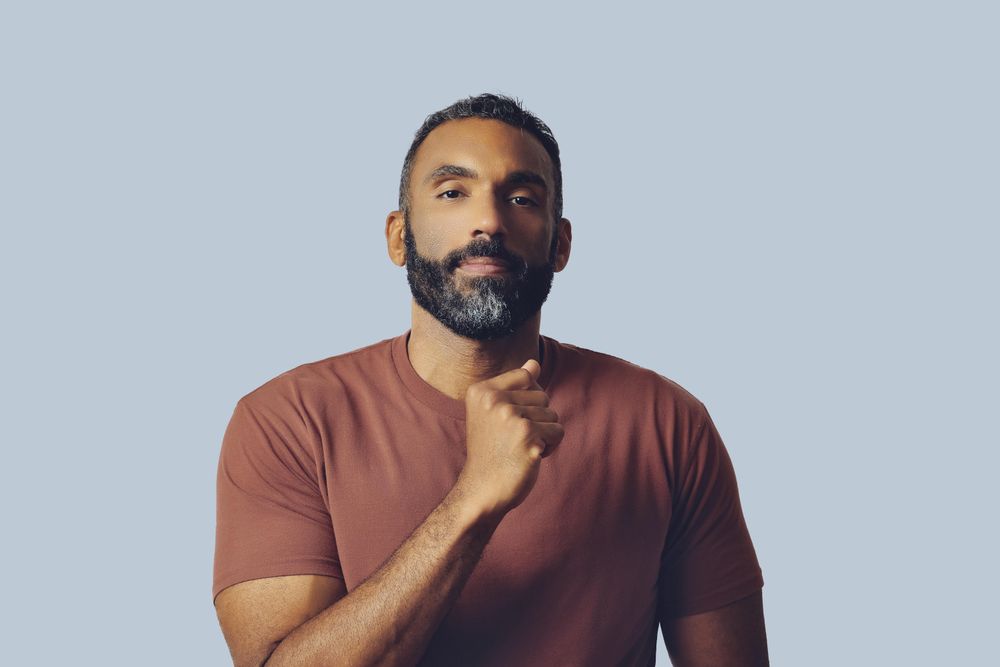 Black male making fist and looking proud in grey studio
