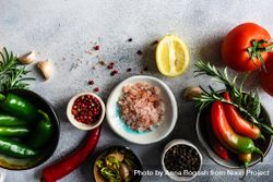 Top view of seasoning with tomatoes, seasoning, garlic & herbs on marble counter 5wXgDm