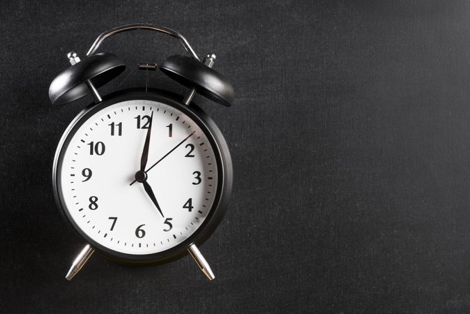 Alarm clock showing 5 o’clock against a dark background