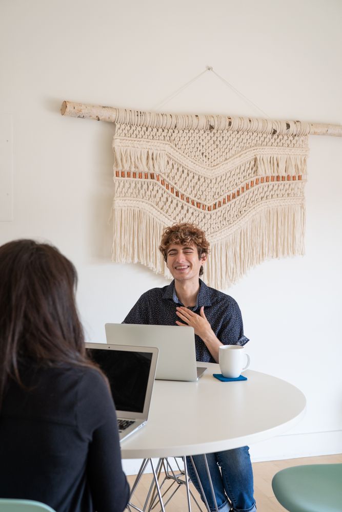 Two colleagues smiling while working casually at a table