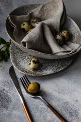 Easter card concept with elegant grey ceramic bowl and speckled eggs