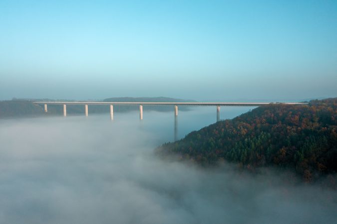 Highway bridge over dense fog, drone aerial view, at sunrise in Germany
