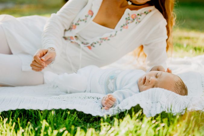 baby with down syndrome lying on a blanket with her grandmother