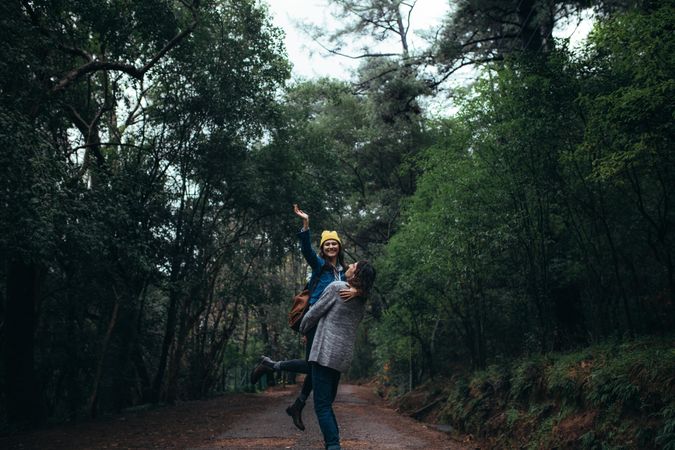 Happy woman in the arms of her boyfriend in a rain forest