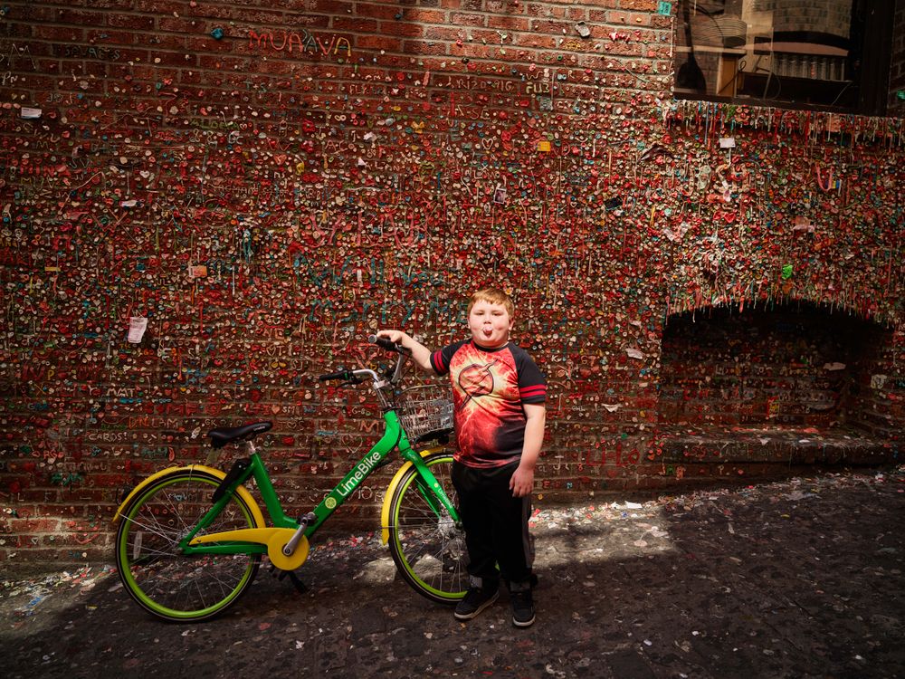 Six-year-old Gregorio Drozco III at the gum wall with a green bike, Seattle, Washington