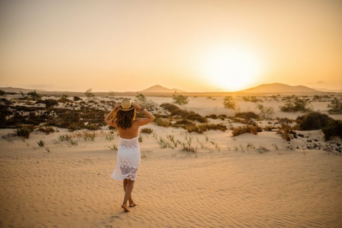 Active woman walking in dry desert barefoot