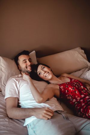 Happy couple cuddling on bed