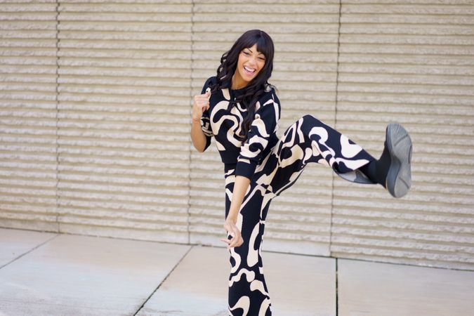 Energetic dancer kicking in the air while performing happily outdoors