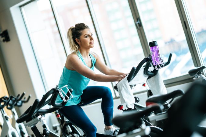Woman with towel and water on exercise machine