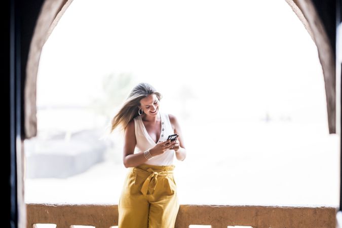 Woman using smartphone in balcony