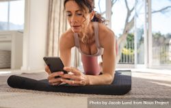Woman looks in the phone online yoga lessons while exercising 56ozY4