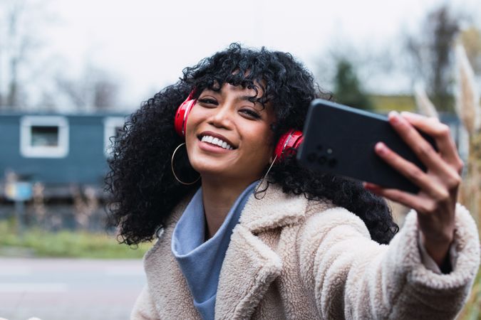 Black woman taking selfie on street