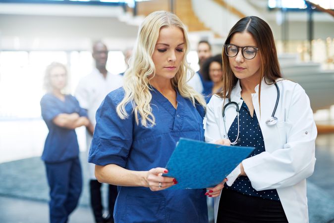 Two women working in the medical field pictured going over a chart