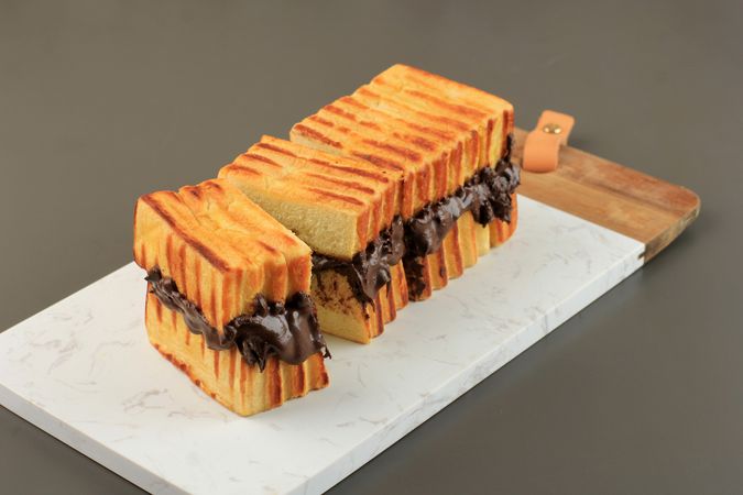 Toasted bread with delicious chocolate spread filling sliced on breadboard