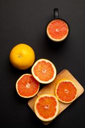 Grapefruits for breakfast near mug and board