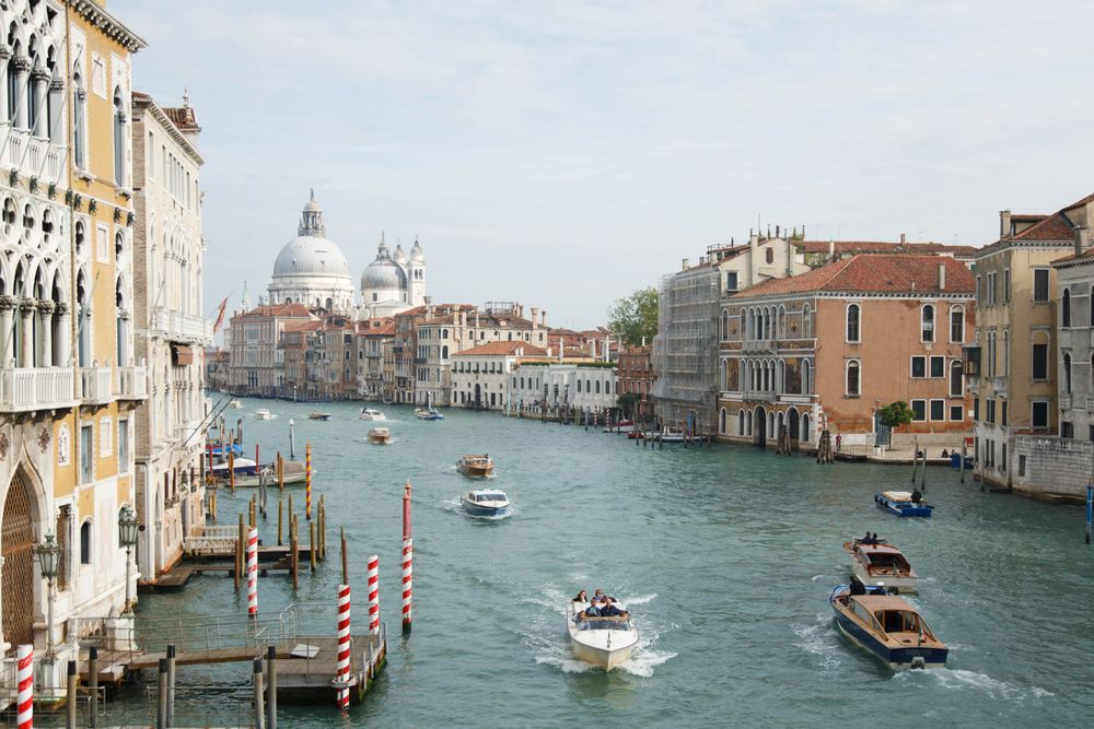 People riding on boat on river near Gallerie dell'Accademia, Italy