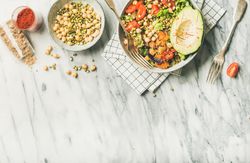 Healthy vegan lunch bowl with avocado, sprouted grains, vegetables, paprika, with copy space
