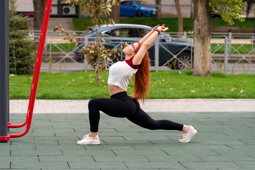Woman doing low lunge stretch with arms extended