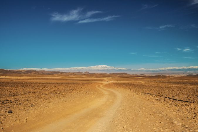 Road between desert and blue sky