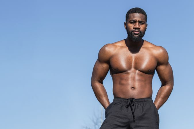 Strong Black sportsman resting during training on sports ground