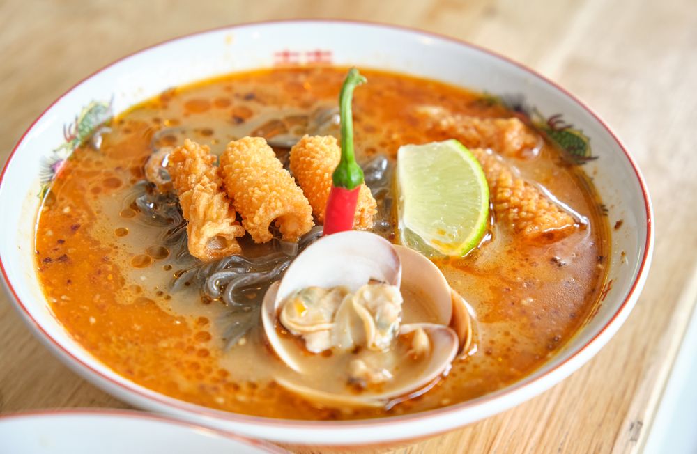 Traditional oriental soup with mussels and crispy chicken skin