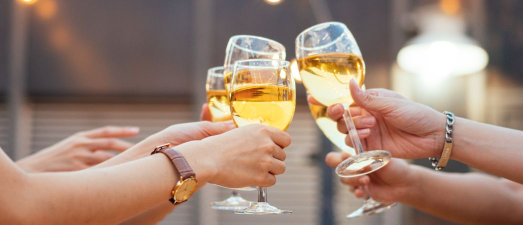 Hands of people toasting glasses of wine at the party