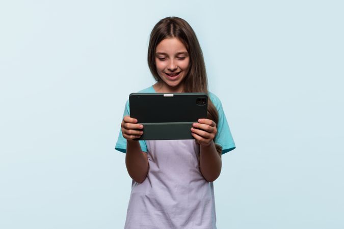 Girl using tablet for entertainment or learning.