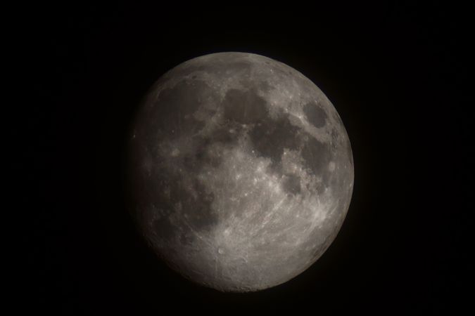 Bright moon in darkness revealing distinct maria and crater patterns