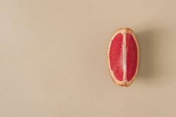 Minimal nature layout with grapefruit slice and pastel sand background