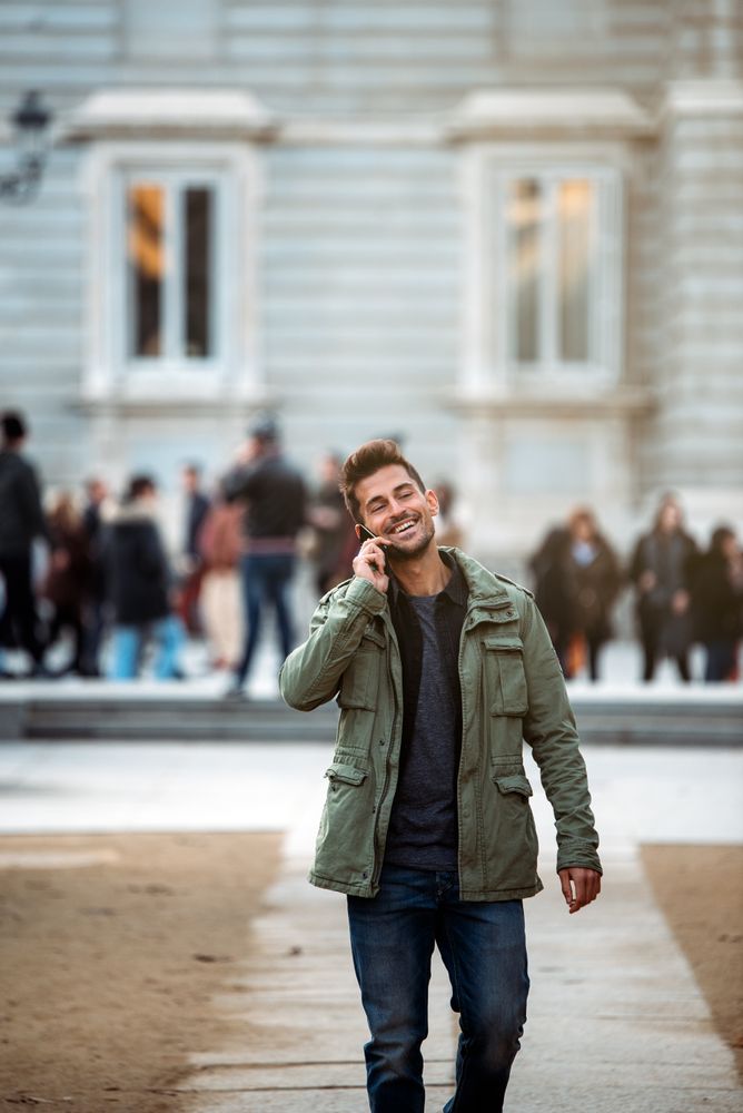 Young man on the mobile phone and walking