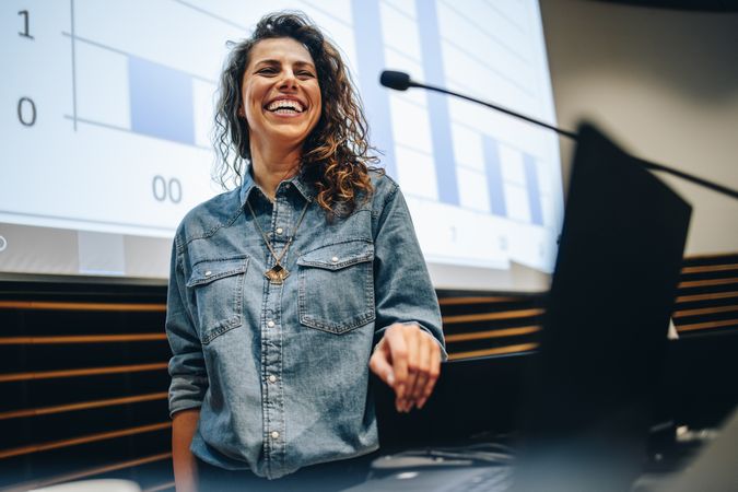Woman speaking at a business summit and smiling