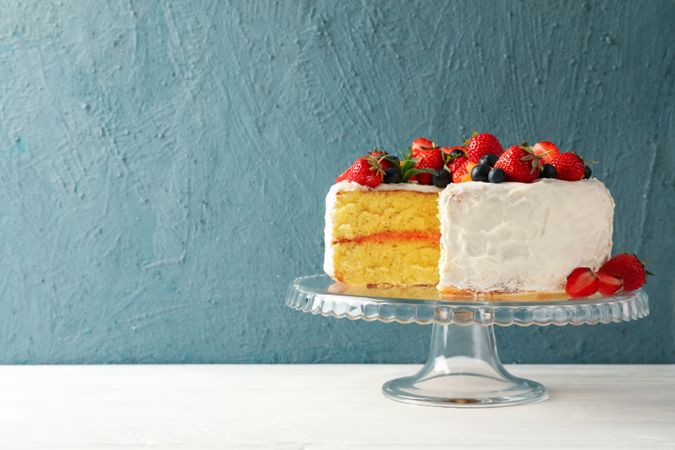 Tray with delicious berry cream cake on wooden table. Tasty dessert
