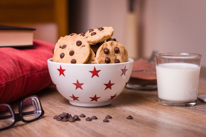 Chocolate chip cookies and milk on wood background