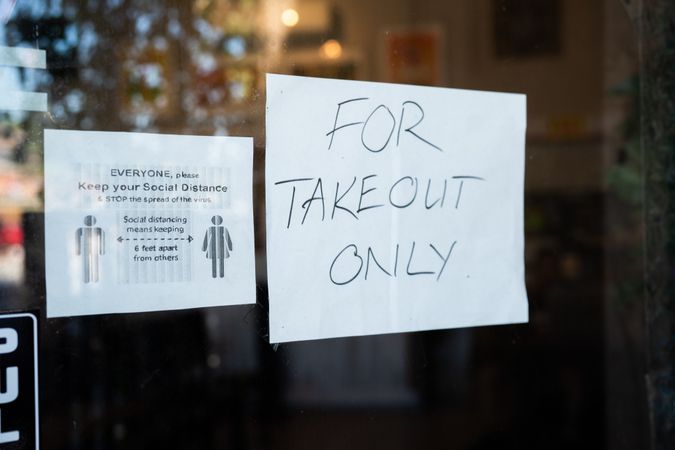 “For take out only” sign in window of restaurant for lockdown