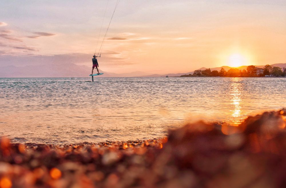 Person doing water sport during sunset