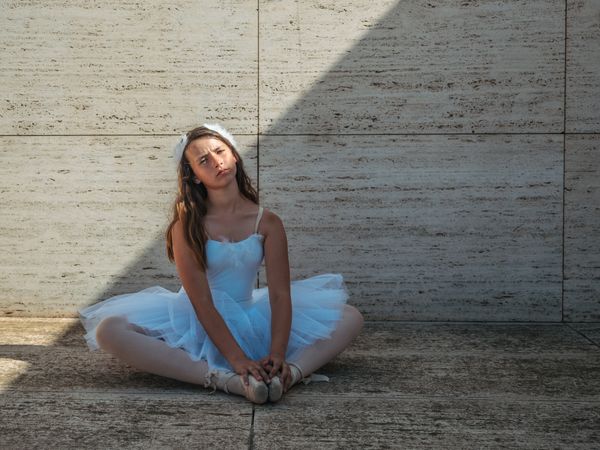 Ballerina sitting on floor stretching