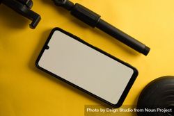 Mock up phone and accessory pieces on yellow background 0yX8wG